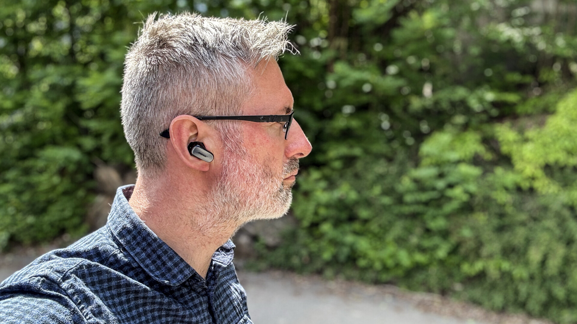 a man wearing glasses and a bluetooth earbud Bose QuietComfort Ultra Earbuds - GeirNordby