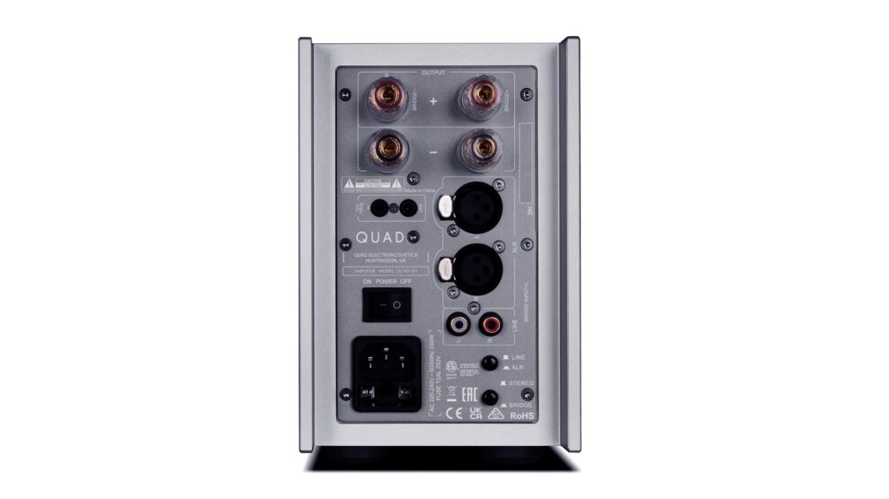 Bakpanel på Quad 303 effektforsterker med fire gullbelagte høyttalerterminaler øverst, strøminntak og hovedbryter, XLR og RCA-innganger, valgbryter for line/XLR og stereo/bridge-modus, samt diverse sertifiseringsmerker.